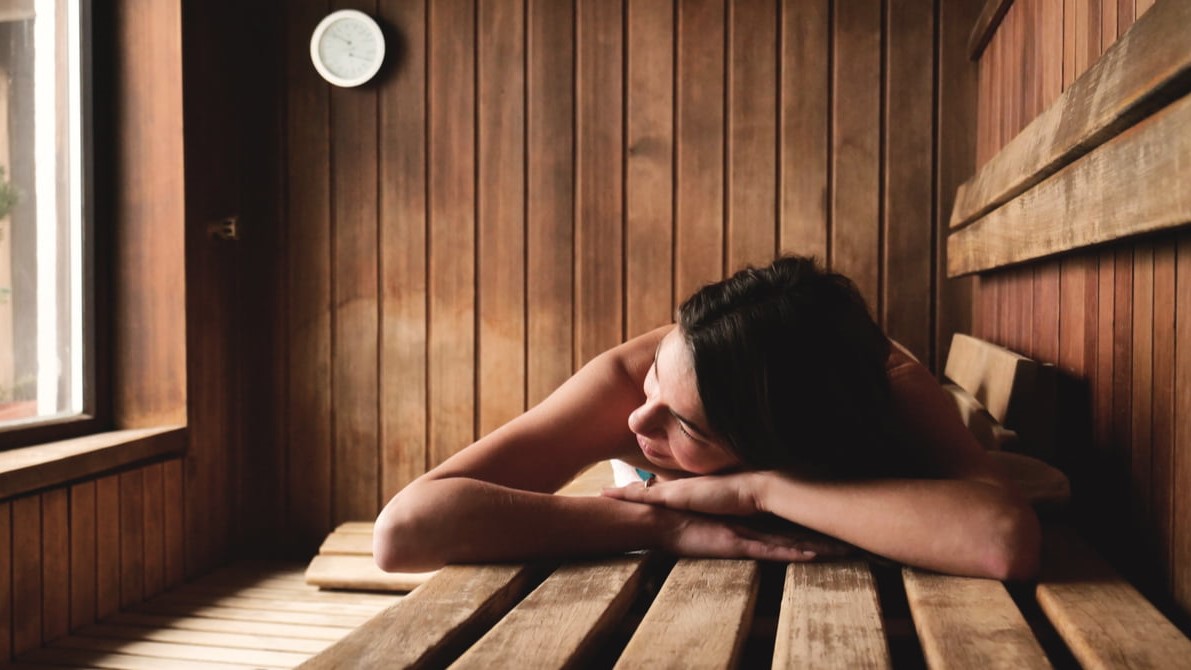 Eine Frau entspannt sich in einer Sauna, die sie sich mit einem Modernisierungskredit gekauft hat.